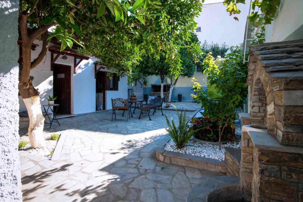 un cortile con sedie e alberi in un edificio di Sweet Home a Volos