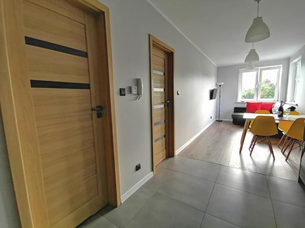 a wooden door in a living room with a table at Apartament Cyprys 2 in Oświęcim