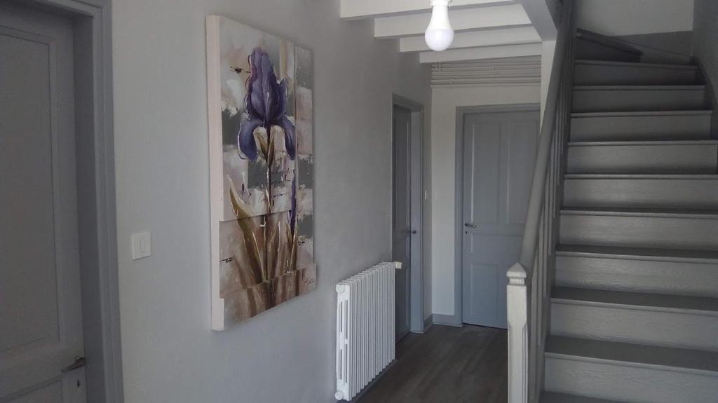 a hallway with a staircase with a painting on the wall at Maison de Romagers in Aumont-Aubrac