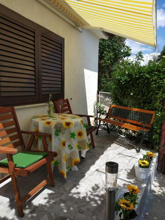a patio with a table and two benches and a table and chairs at Apartman Manuela in Matulji