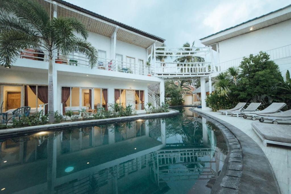 a swimming pool in front of a house at Gili Amor Boutique Resort in Gili Trawangan