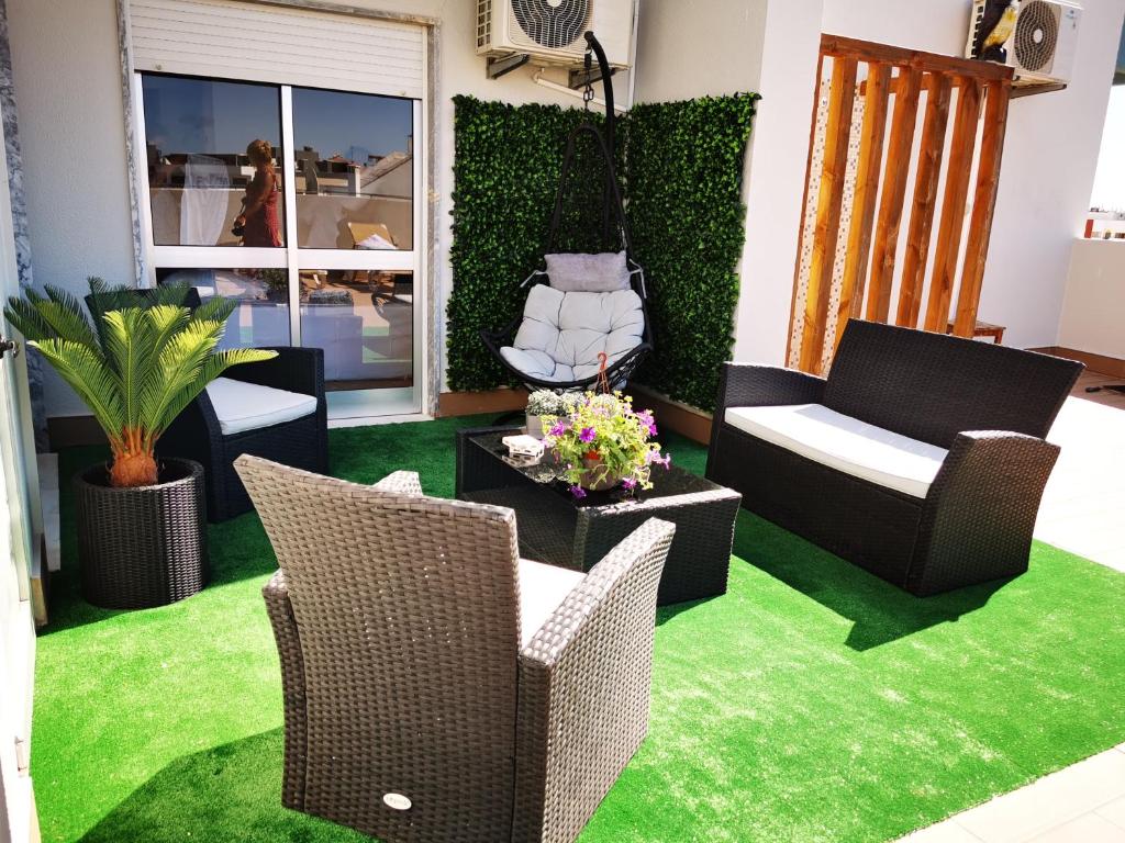 ポルティマンにあるPenthouse T3 com Terraço e BBQの緑の芝生と家具が備わるリビングルーム