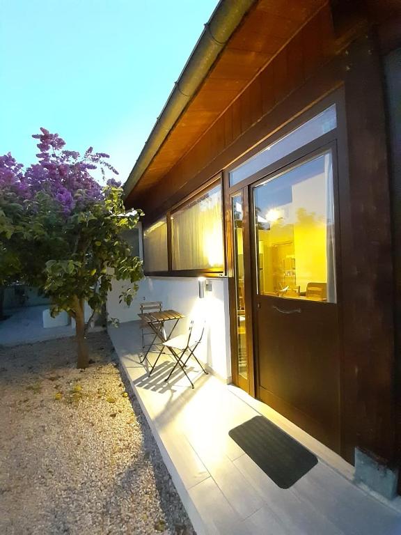 a door to a house with a table and a tree at Una piccola casa al mare in San Domino