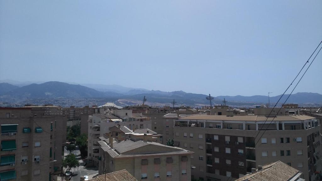 a city with buildings and mountains in the background at Disfruta Granada,incluso con tu mascota Parking in Granada