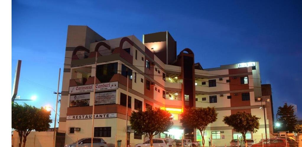 a building with cars parked in front of it at Suíte Hotel Vitória in Vitória