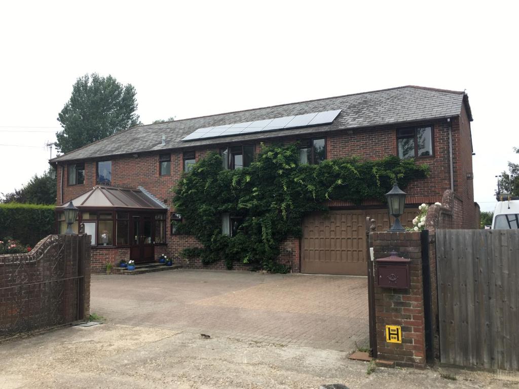 uma casa de tijolos com um portão e uma cerca em High View Retreat em Lewes