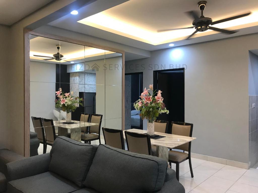 a dining room with tables and chairs and a ceiling fan at Cozy Apartment @ Hospital Sungai Buloh in Sungai Buluh