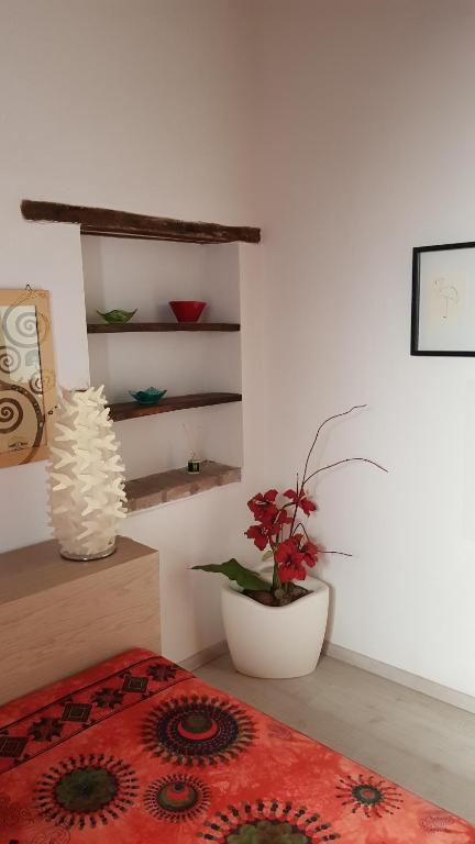 Habitación con cama y jarrón con planta en La Casina di Neda, en Civitella Marittima