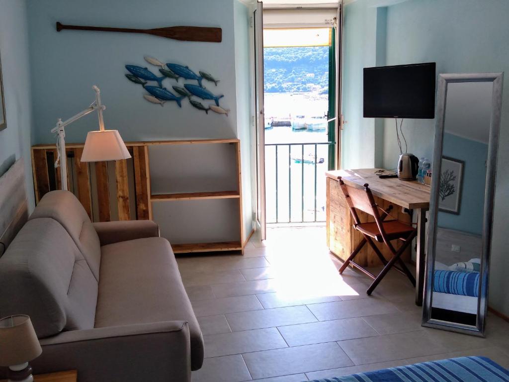 ein Wohnzimmer mit einem Sofa und einem Schreibtisch in der Unterkunft La Calata in Porto Venere
