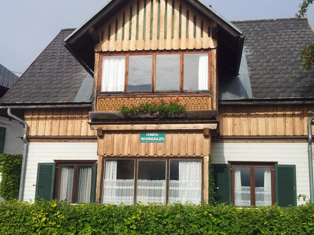 ein Haus mit einem Fenster mit Blumen darauf in der Unterkunft Appartements direkt am See in Grundlsee