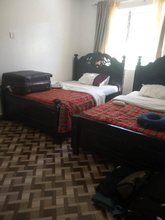 Postel nebo postele na pokoji v ubytování Kenya Inn