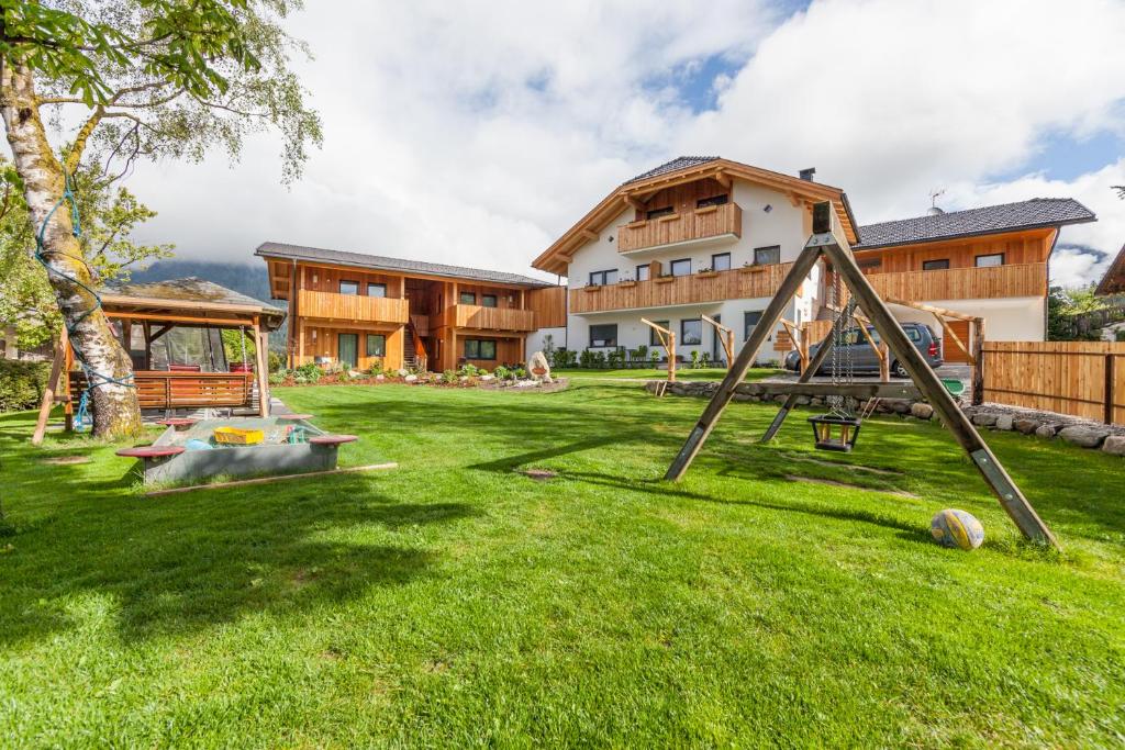 einen Hof mit Spielplatz vor einem Haus in der Unterkunft Winklerhof Apartments in Bruneck