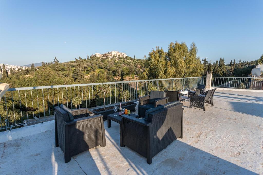 a balcony with couches and chairs on a roof at Acropolis Luxury Iris by GK Properties in Athens