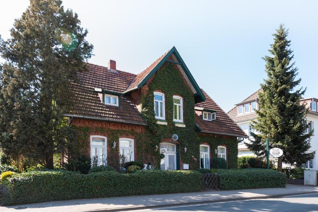een rood bakstenen huis met een groen dak bij Pension Schneiderstübchen Hambergen in Hambergen