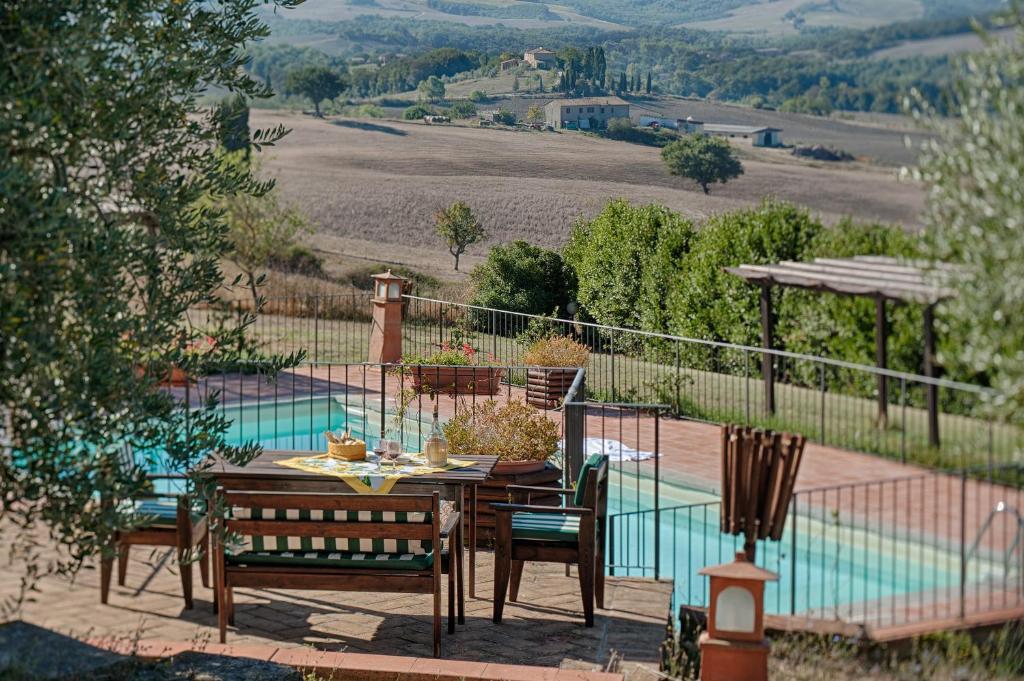 a patio with a table and chairs next to a pool at Podere La Ciabatta in Casole dʼElsa