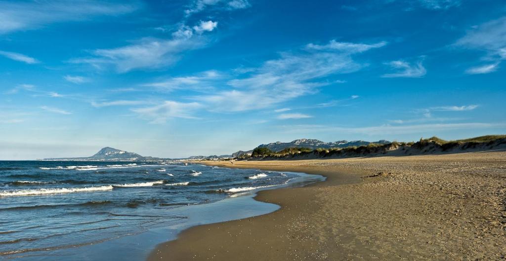 einen Strand mit Meer und Bergen im Hintergrund in der Unterkunft Villa Santana in Oliva
