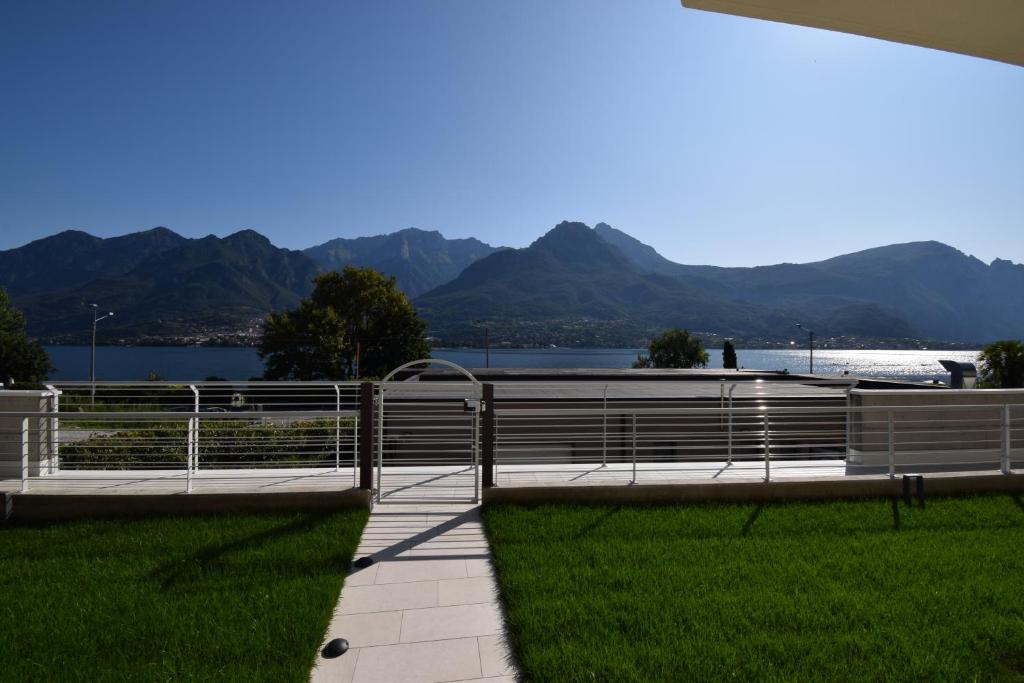 uma cerca com vista para a água e para as montanhas em Appartamento Narciso - Facing lake Como Bellagio Wild Flowers em Oliveto Lario