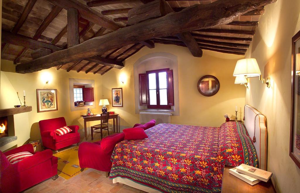 a bedroom with a bed and two red chairs at Romantic House in Greve in Chianti