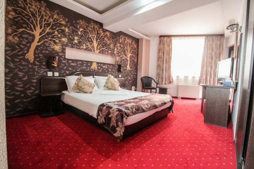 Habitación de hotel con cama y alfombra roja en Hotel Razvan en Bucarest