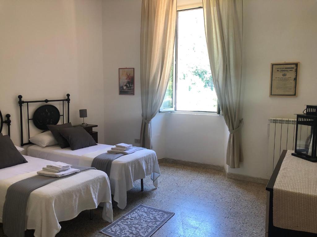 sypialnia z dwoma łóżkami i oknem w obiekcie Central House Terracina w mieście Terracina