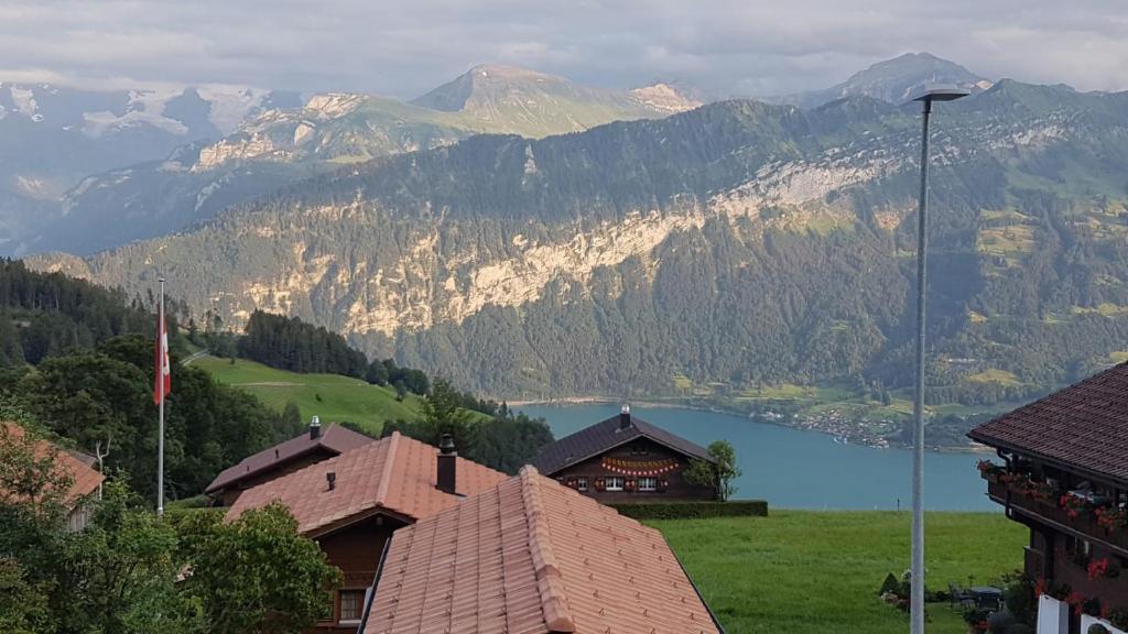 uma vista para um lago e montanhas com uma casa em App. Seeblick Top of Interlaken em Beatenberg