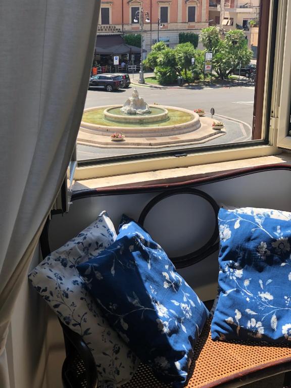 dwie niebieskie poduszki siedzące na ławce przed oknem w obiekcie Central House Terracina w mieście Terracina