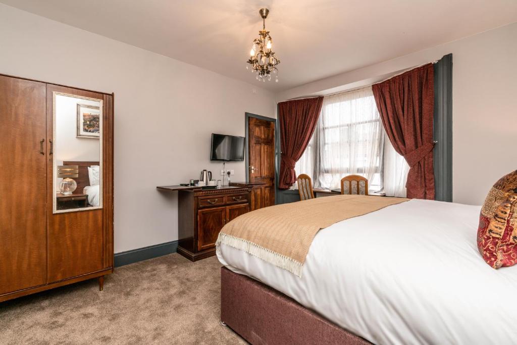 a bedroom with a bed and a dresser at Cappadocia Guest House in Brighton & Hove