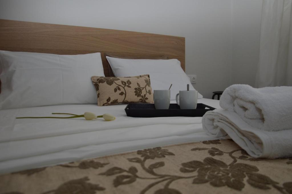 a bed with white sheets and towels and candles on it at White Tower Apartment in Thessaloniki