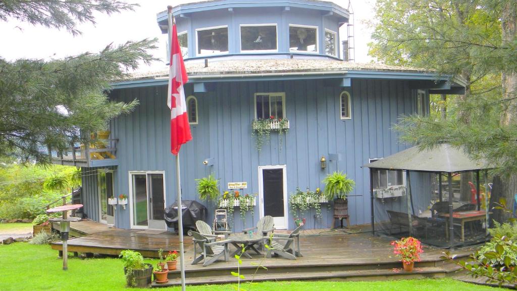 a blue house with a flag in front of it at Stouffermill Bed & Breakfast in Algonquin Highlands