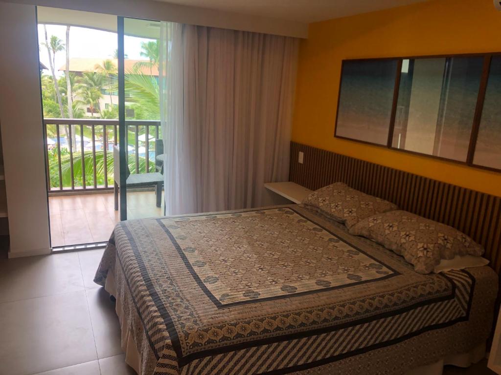 a bedroom with a bed with a view of a balcony at Marulhos resort Muro Alto in Porto De Galinhas
