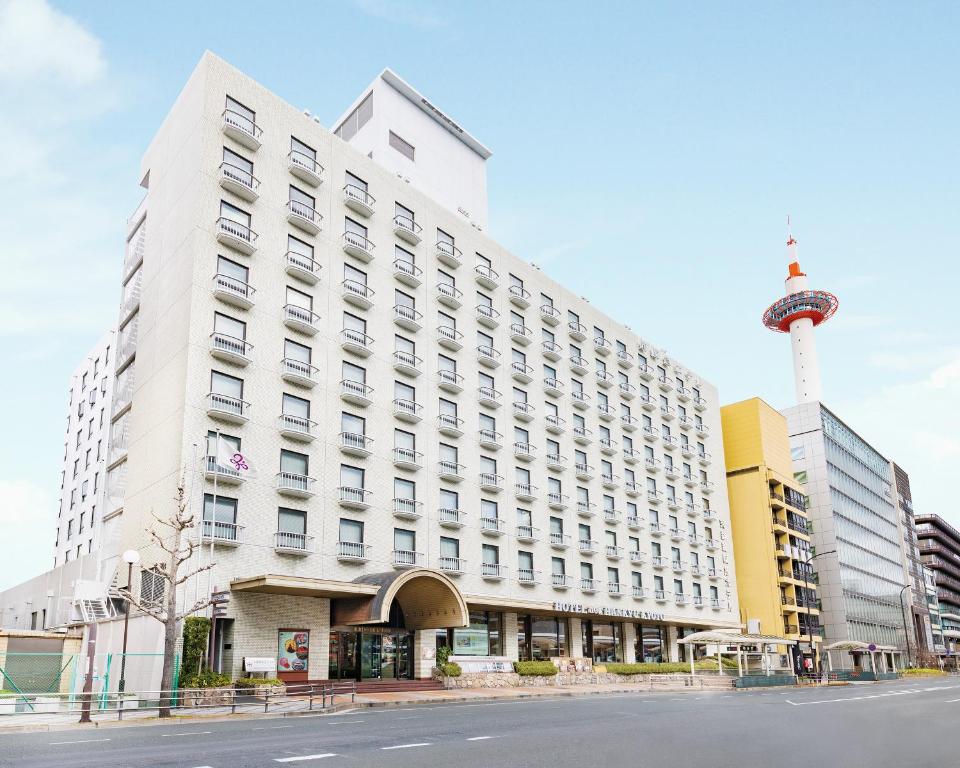 a large white building with a tower in the background at Hotel New Hankyu Kyoto in Kyoto