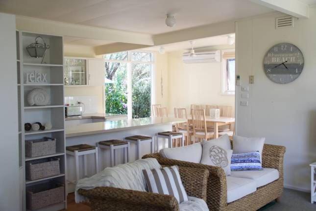 a living room with a couch and a kitchen at Blairgowrie Beach Escape in Blairgowrie