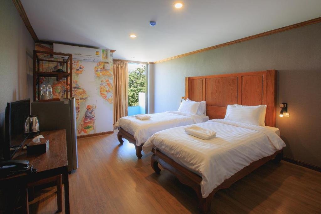 A twin bedroom with two separate beds, a television and a bright garden-facing opening.