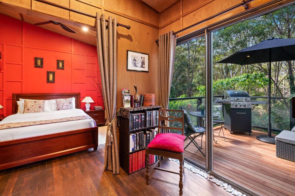 a bedroom with a bed, a desk, and a window at Noosa Hinterland Retreat in Tinbeerwah