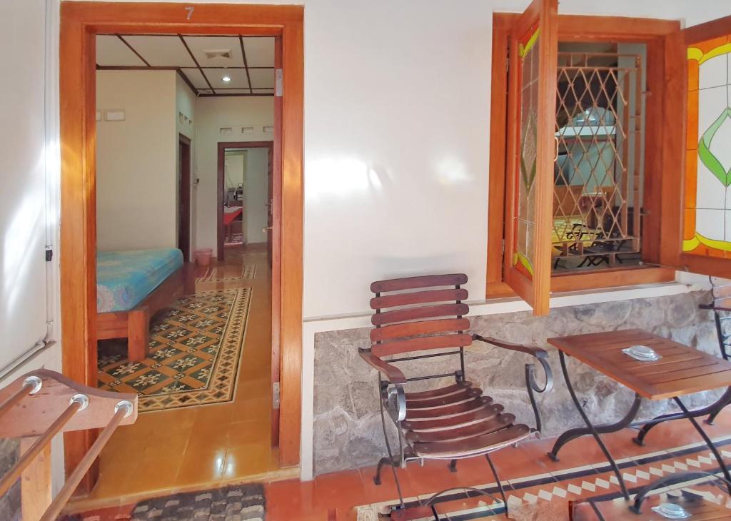 a hallway with chairs and a table and a room at Omah Pitoe Yogya Homestay in Yogyakarta