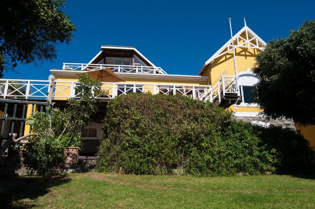 uma casa amarela com um arbusto à frente em Alte Villa Gästehaus em Lüderitz