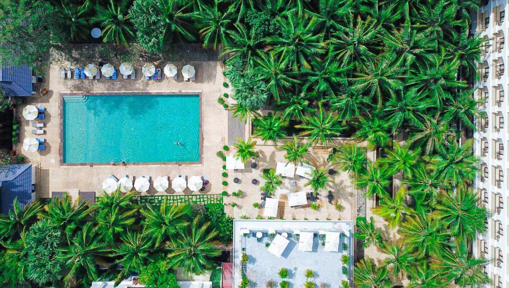 an aerial view of a resort with a swimming pool and palm trees at THE PRIVILEGE FLOOR by Lotus Blanc in Siem Reap