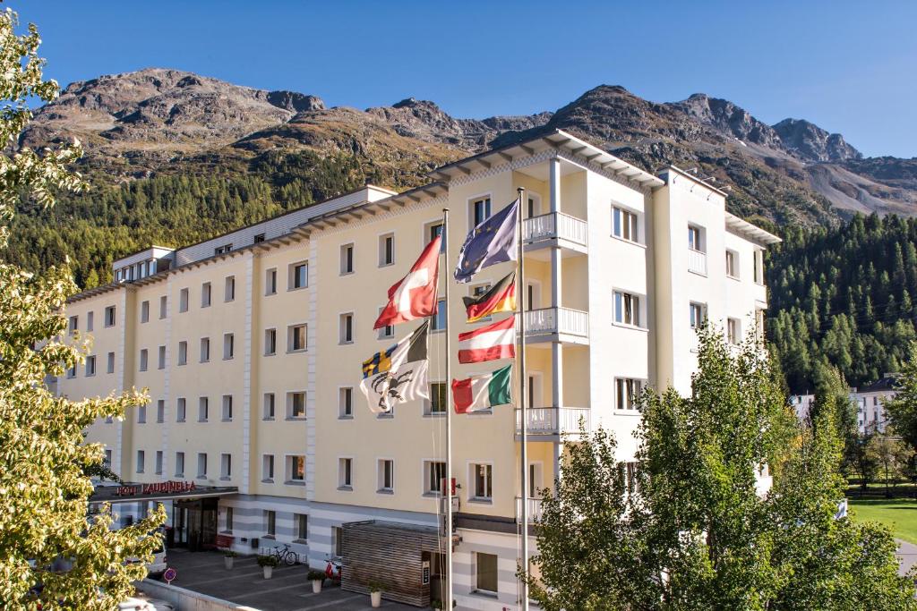 um edifício com bandeiras na lateral em Hotel Laudinella em St. Moritz