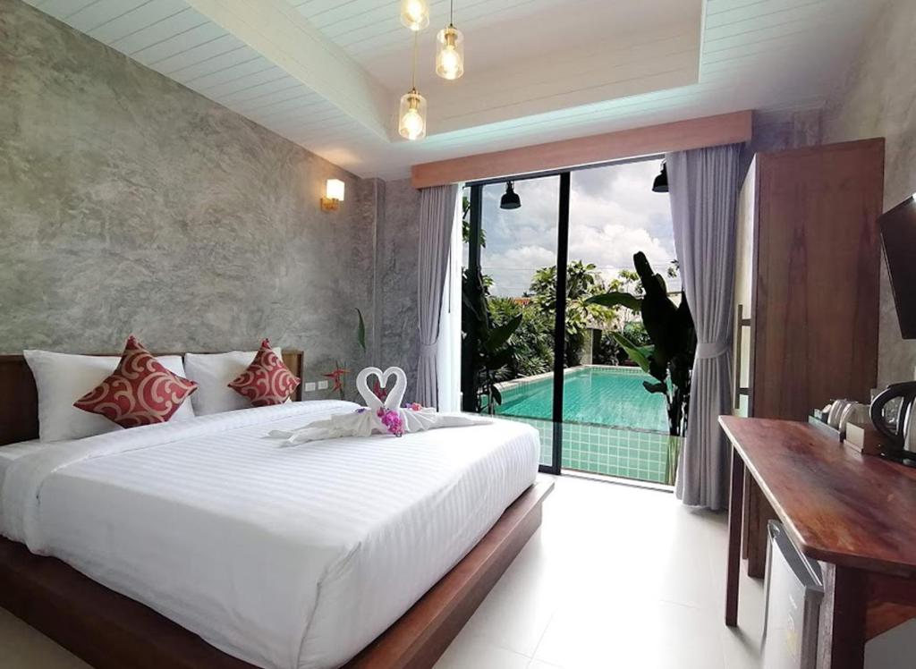 a bedroom with a bed and a swimming pool at JR Place in Klong Muang Beach