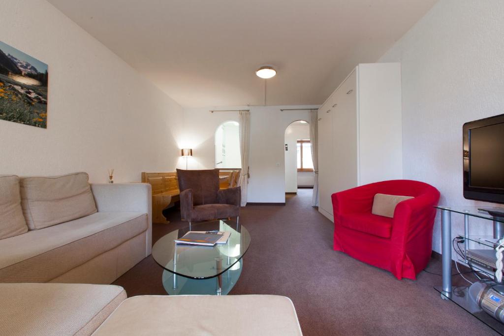 sala de estar con sofá y silla roja en Residenz Alpina 115, en Lenzerheide