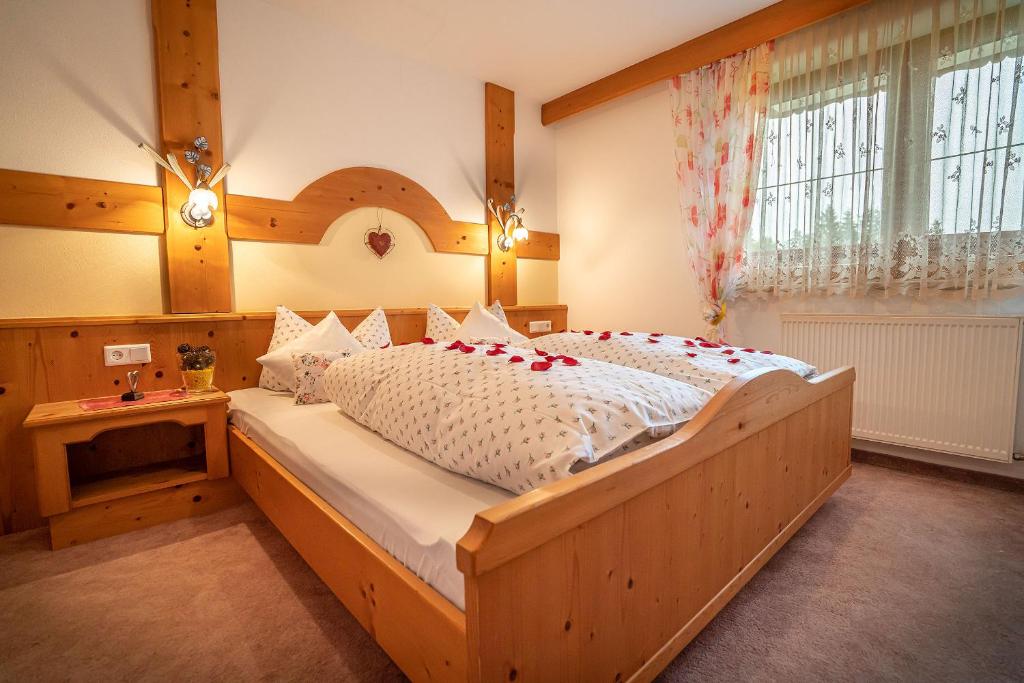 a bedroom with a large wooden bed with roses on it at Haus am Waldrand in Leutasch