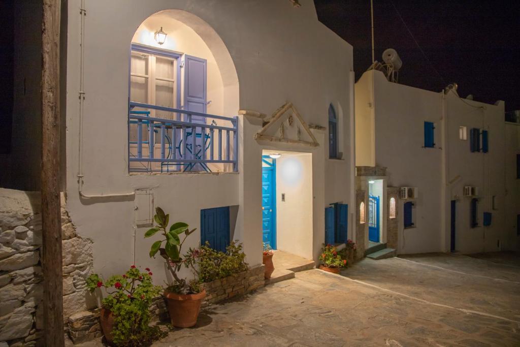 un callejón con edificios blancos con puertas y plantas azules en Amorgaia 2, en Katápola