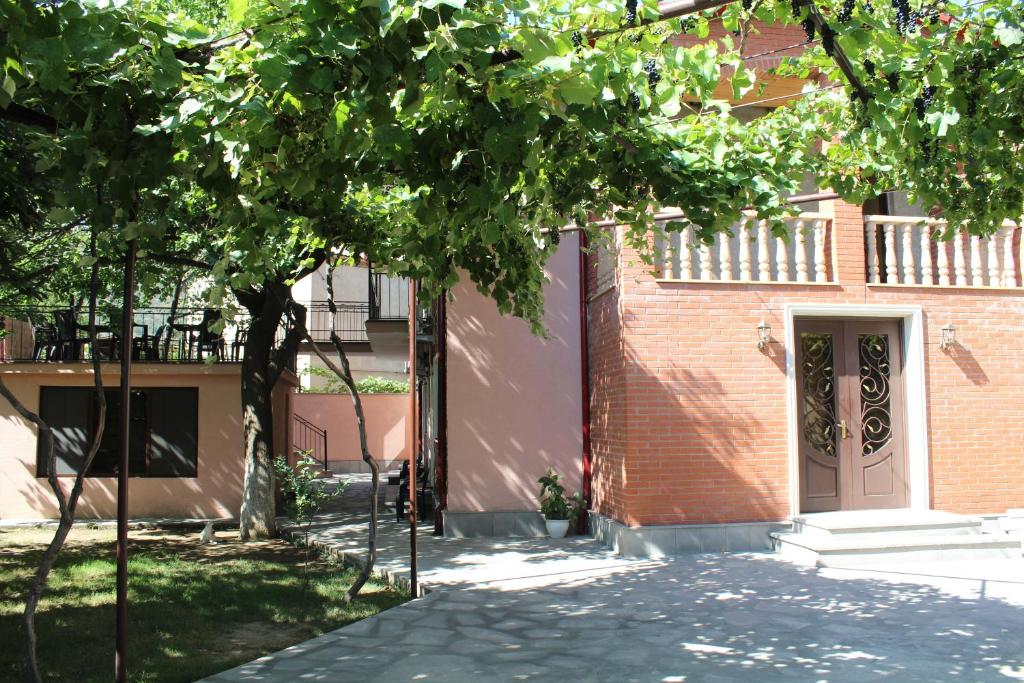 a brick building with a door and a tree at Emis Hotel in Tbilisi City