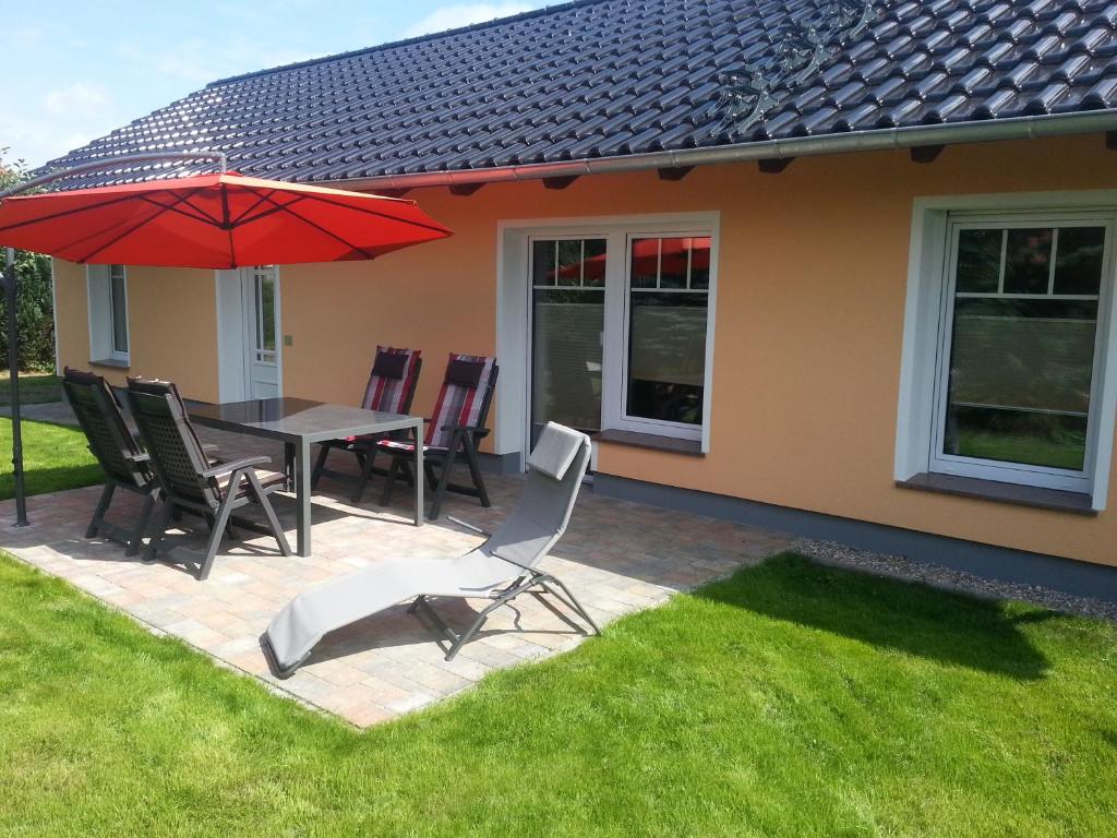 a patio with a table and chairs and an umbrella at Ferienhaus Michelson in Ostseebad Karlshagen