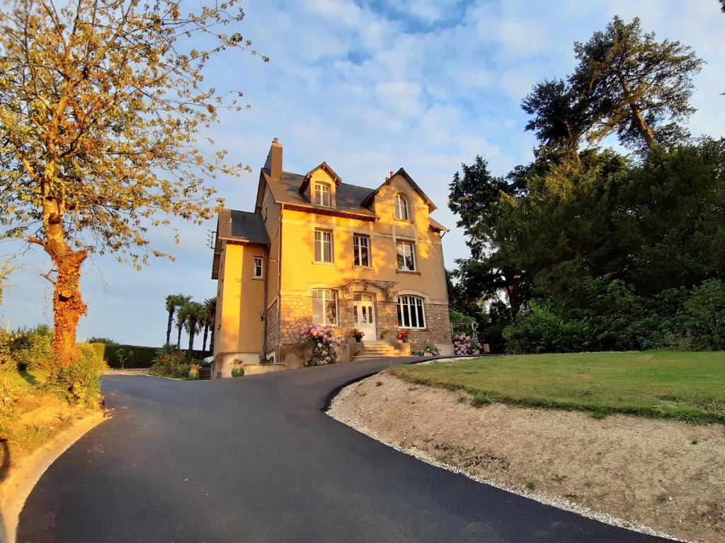 una gran casa amarilla con entrada en La Garenne, en Bricquebec