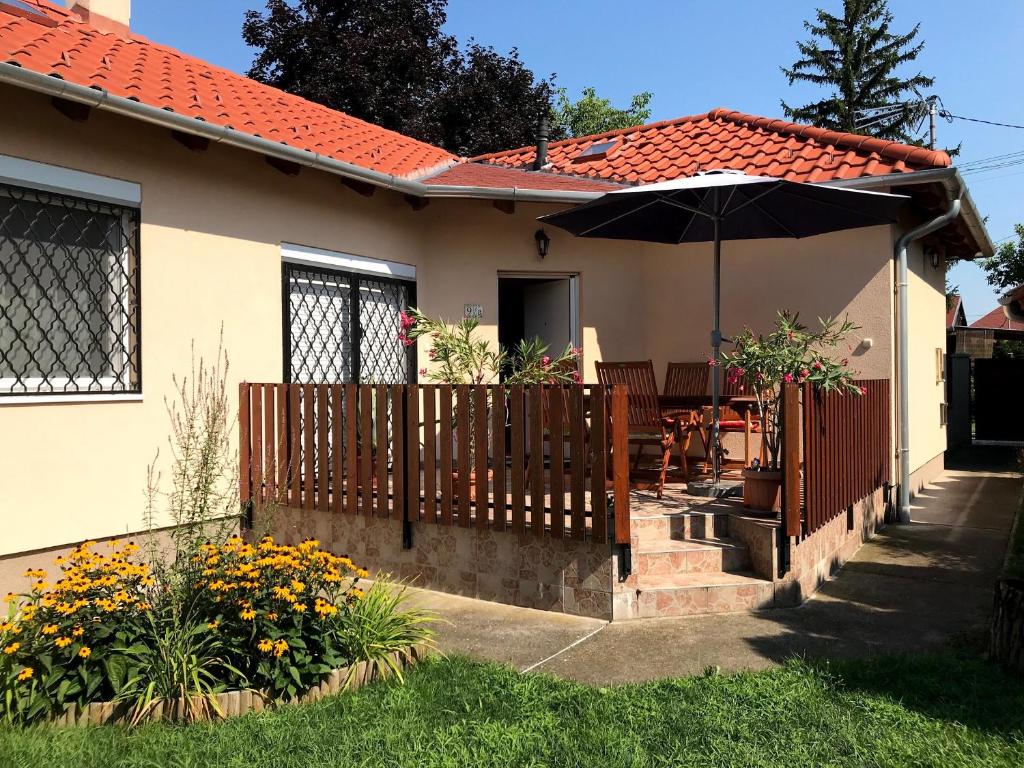 a house with an umbrella and a patio at Lily House in Balatonvilágos