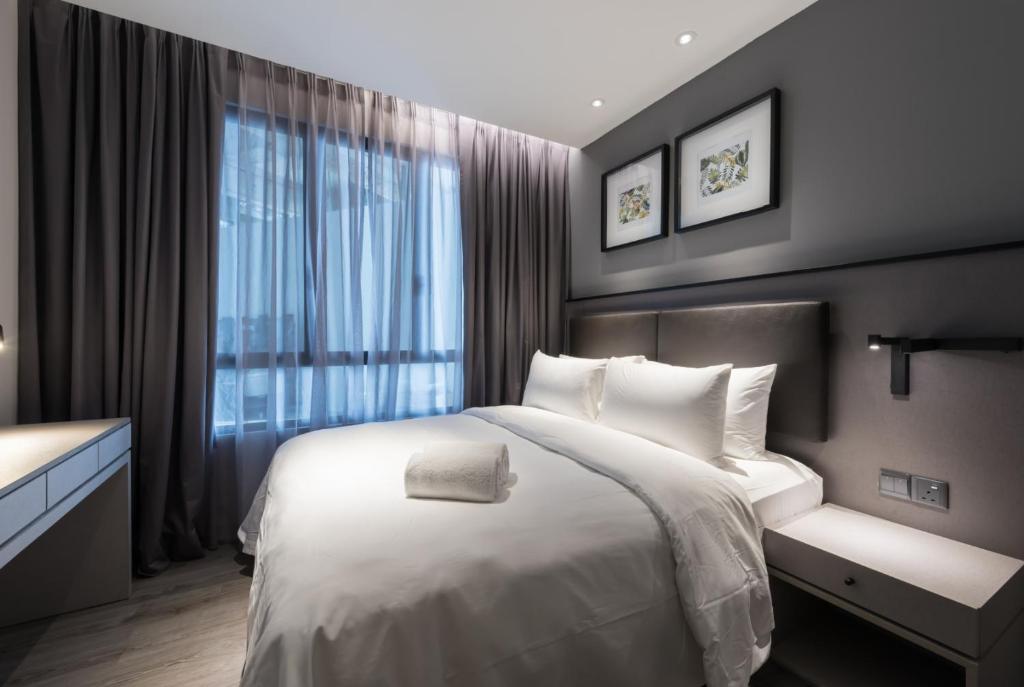 A compact dark-accented bedroom with a double bed, window, bedside tables and wall-mounted artwork.