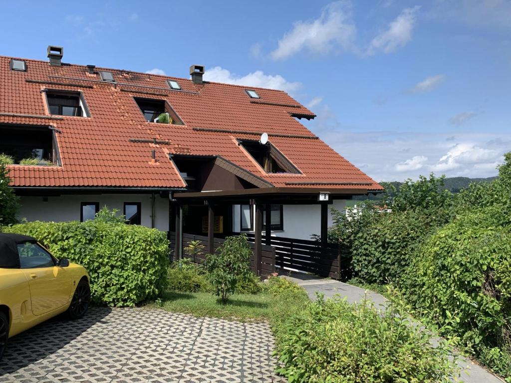 una casa con un coche amarillo aparcado delante de ella en Ferienwohnung Voges, en Bad Lauterberg