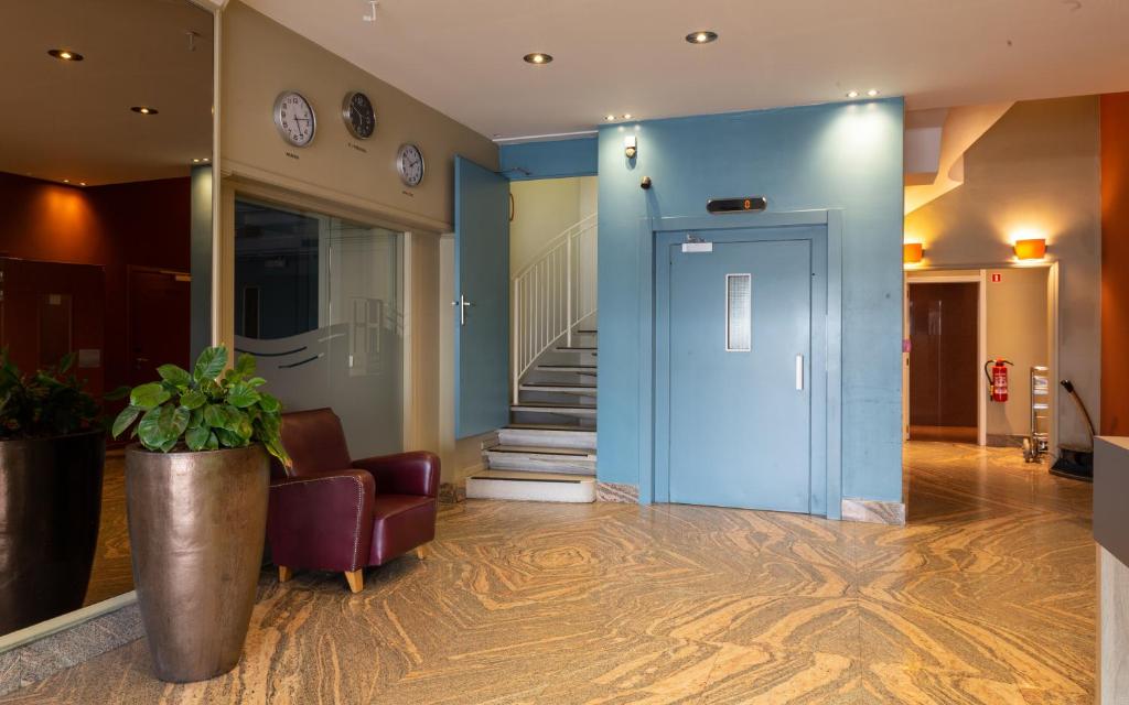 a lobby with a blue door and a plant at Antwerp Harbour Hotel in Antwerp