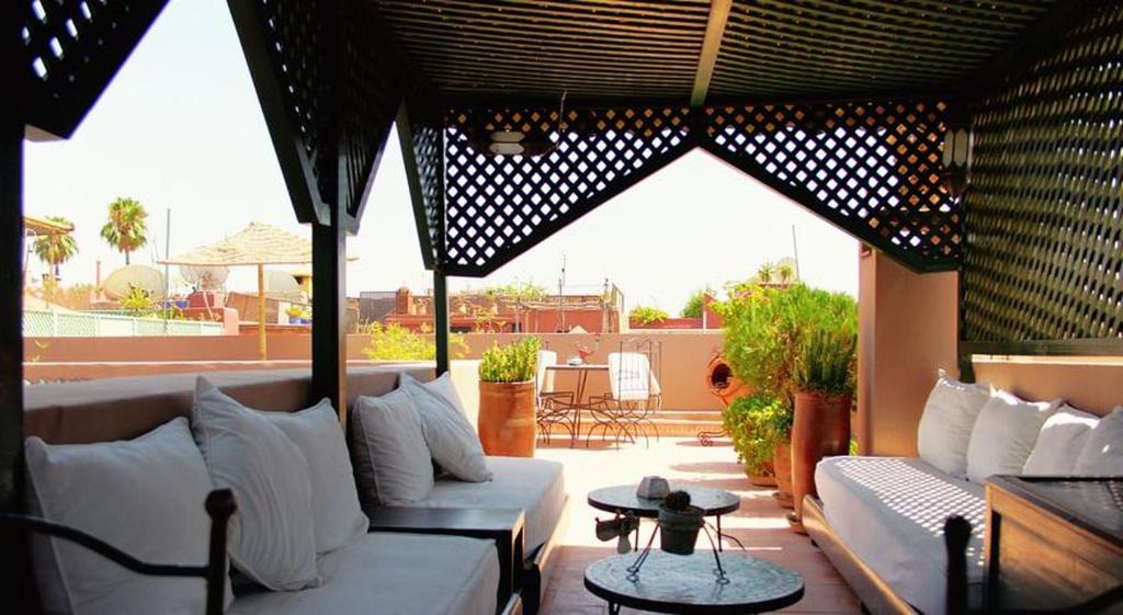um pátio com sofás e uma mesa num alpendre em Riad Al Karama em Marrakech